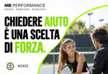 Adolescente con racchetta da tennis che parla con un adulto a bordo campo